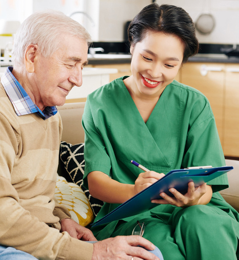 Female community health provider reviewing health form with senior man.